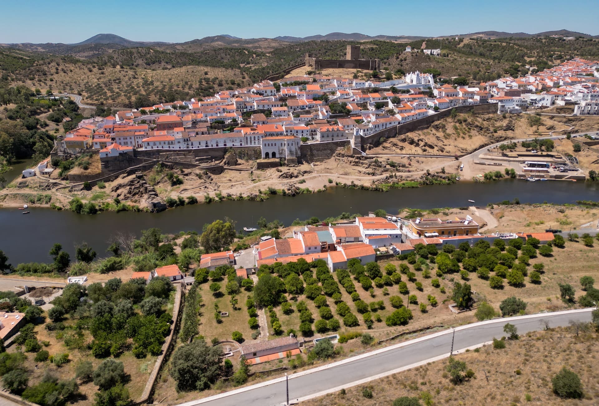 Vista aérea de Mértola com o castelo, a vila branca e o rio Guadiana ao fundo