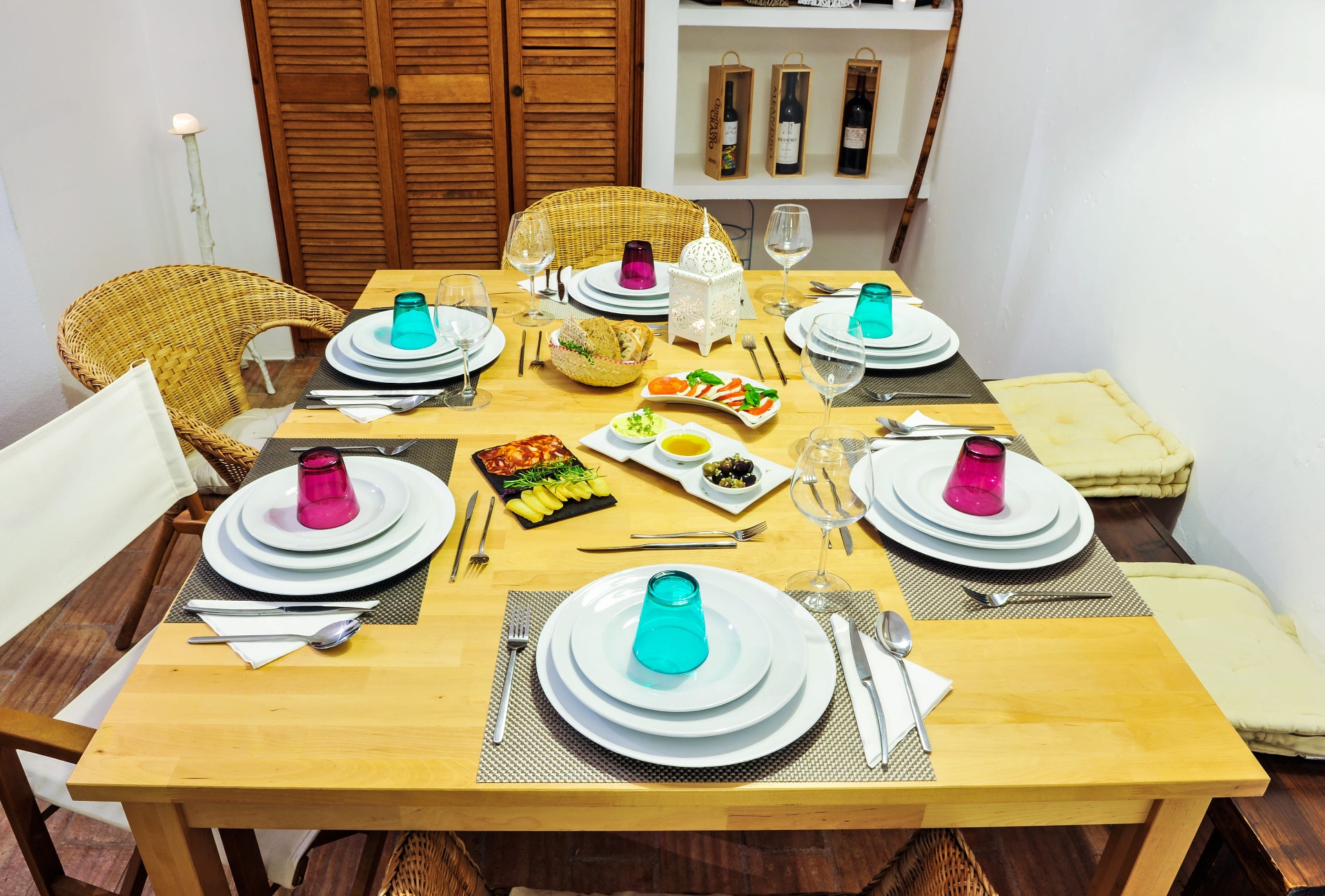 Mesa preparada para refeição com couvert de enchidos, queijo e azeitonas