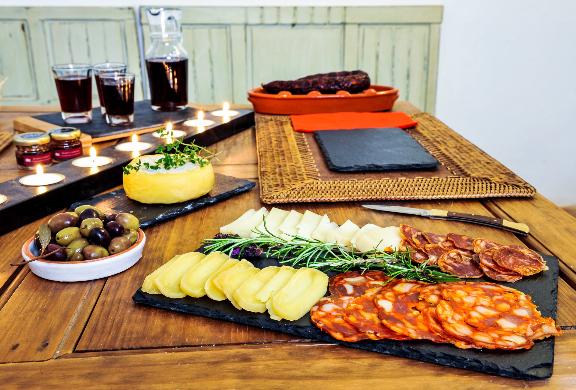 Tábua de queijos, enchidos e azeitonas com vinho tinto