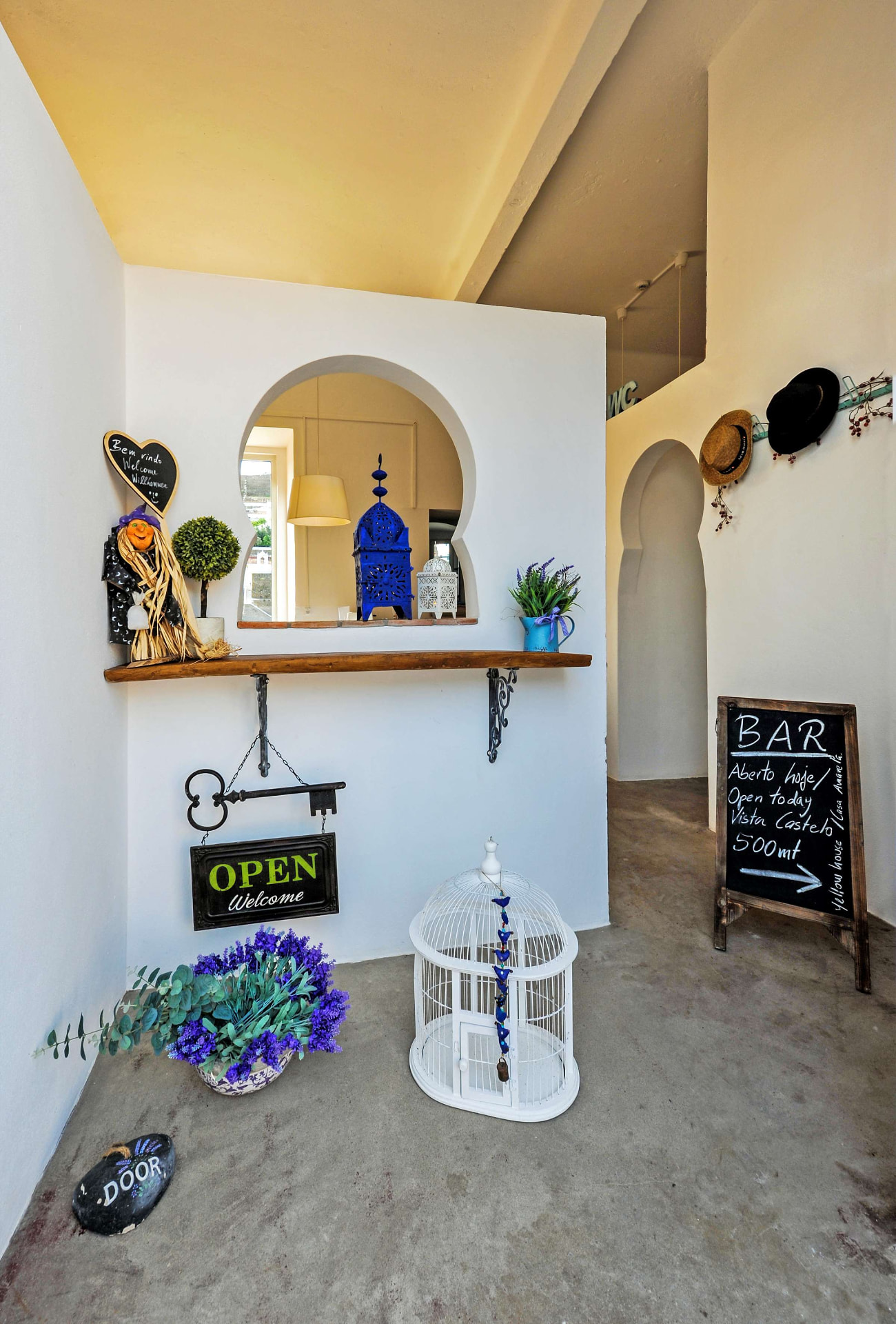 Entrada da Casa Amarela com arco mourisco, decoração artesanal e ardósia de boas-vindas