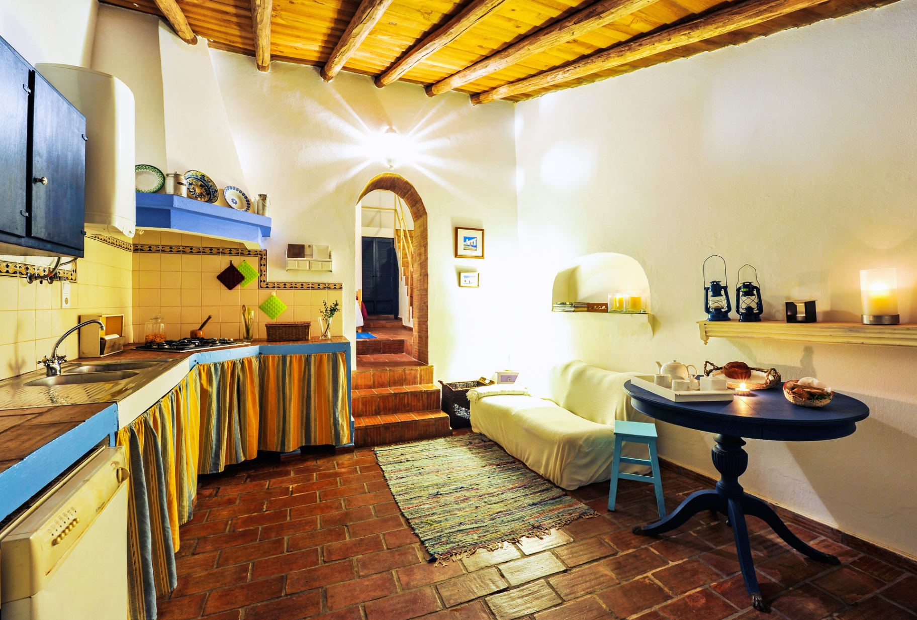 Sala de estar acolhedora da Casa Amarela com sofá branco e arco em pedra