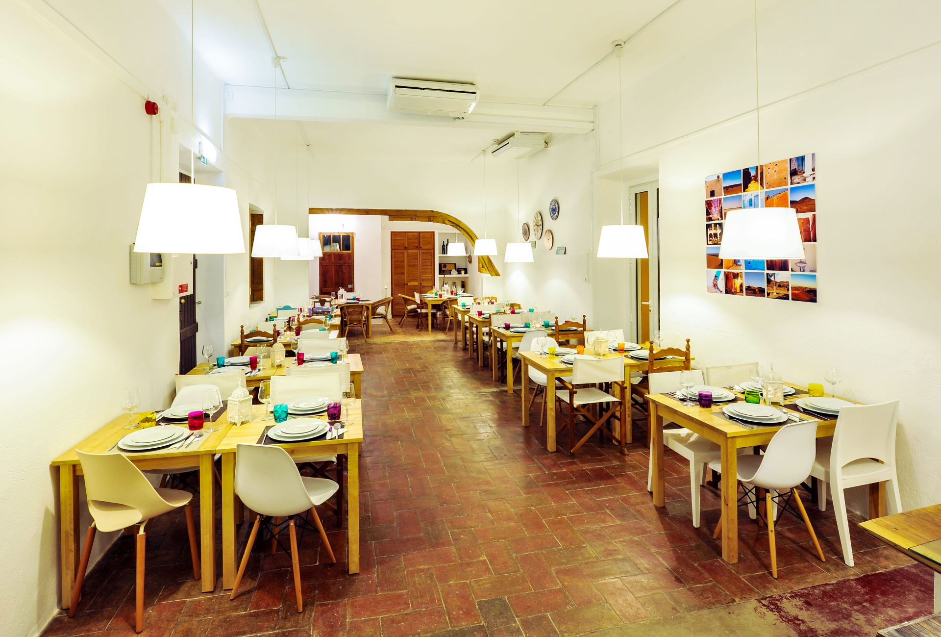 Sala de refeições da Casa Amarela com mesas de madeira e decoração luminosa